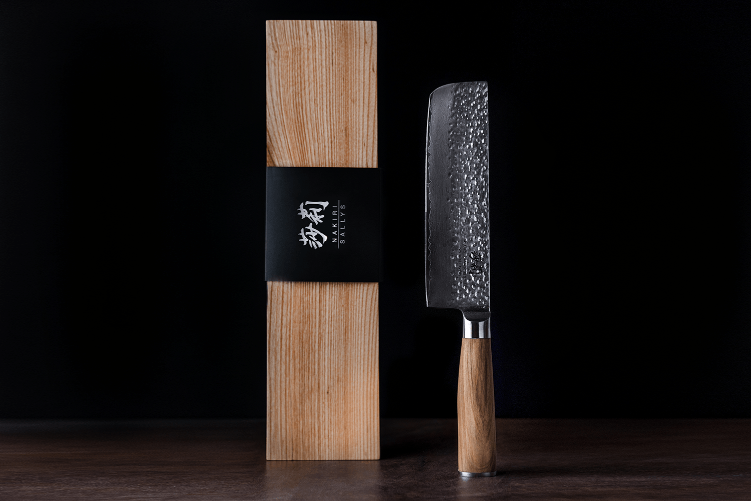 Ein silbernes Messer mit hölzernem Griff und einer Holzbox daneben