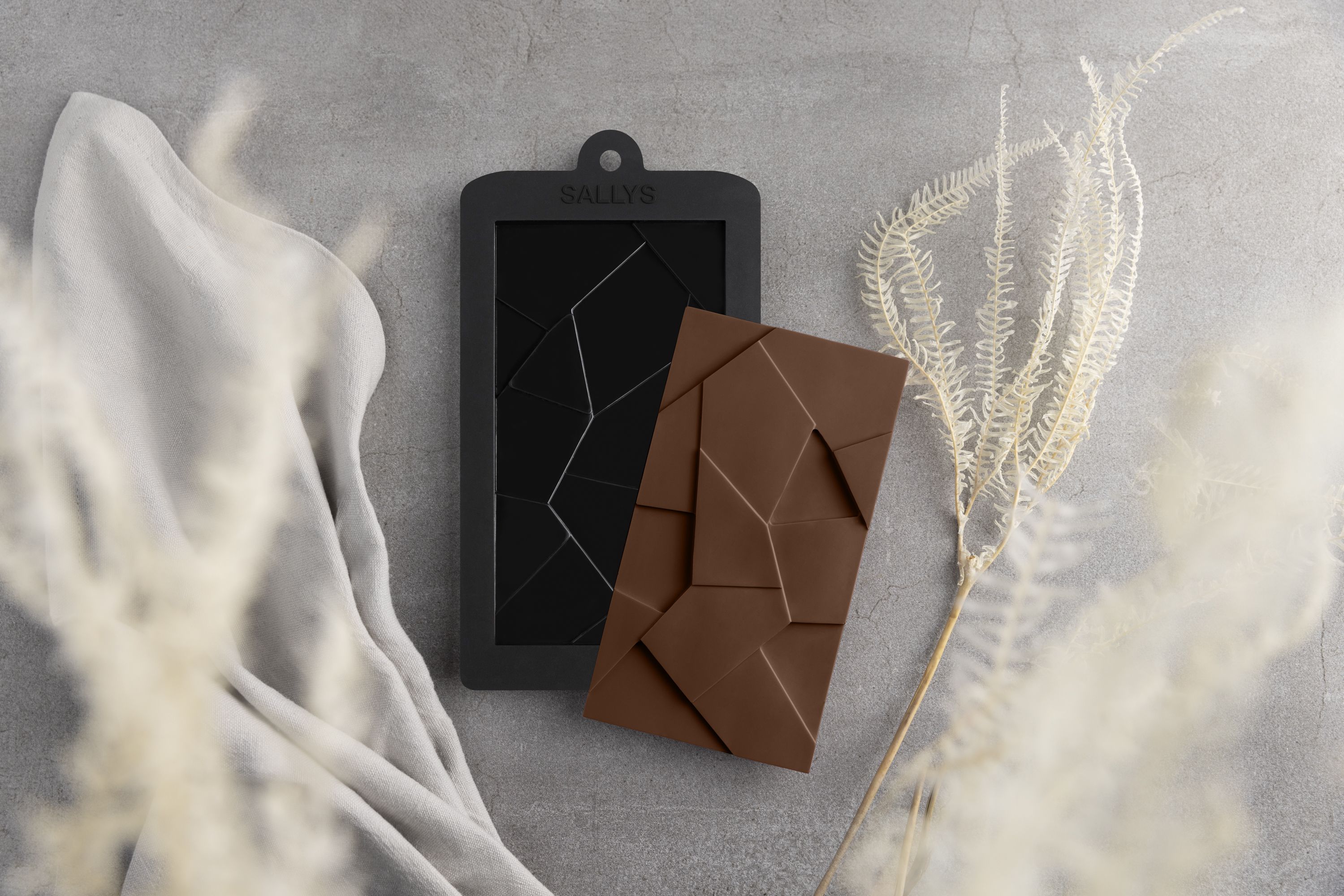 Eine Schokoladenform für Schokolade in Splitteroptik liegt auf einem Tisch