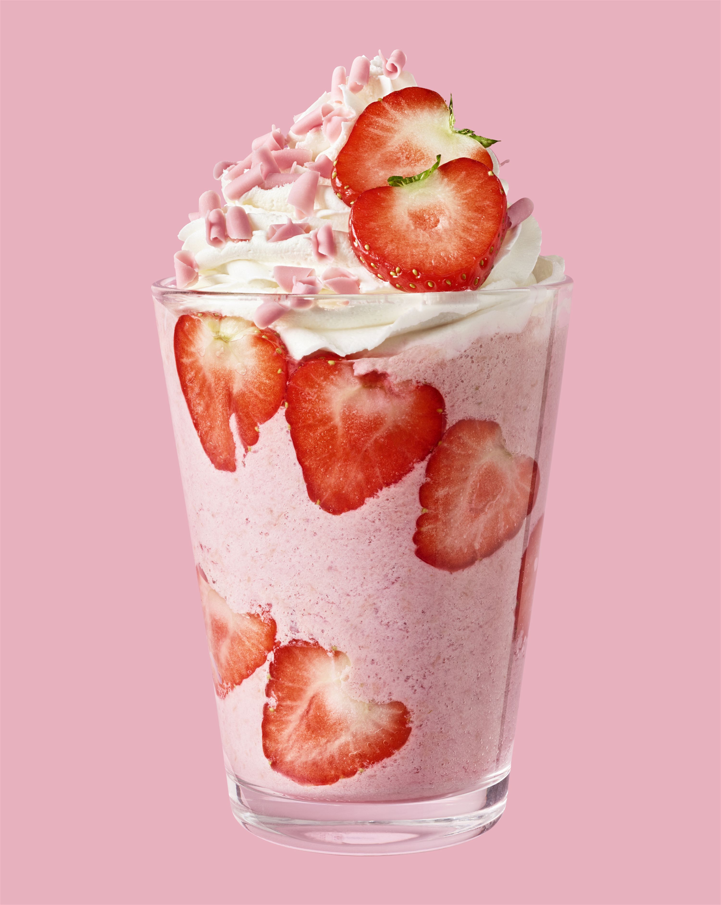 Ein Glas mit Erdbeeren und rosa-milchiger Flüssigkeit