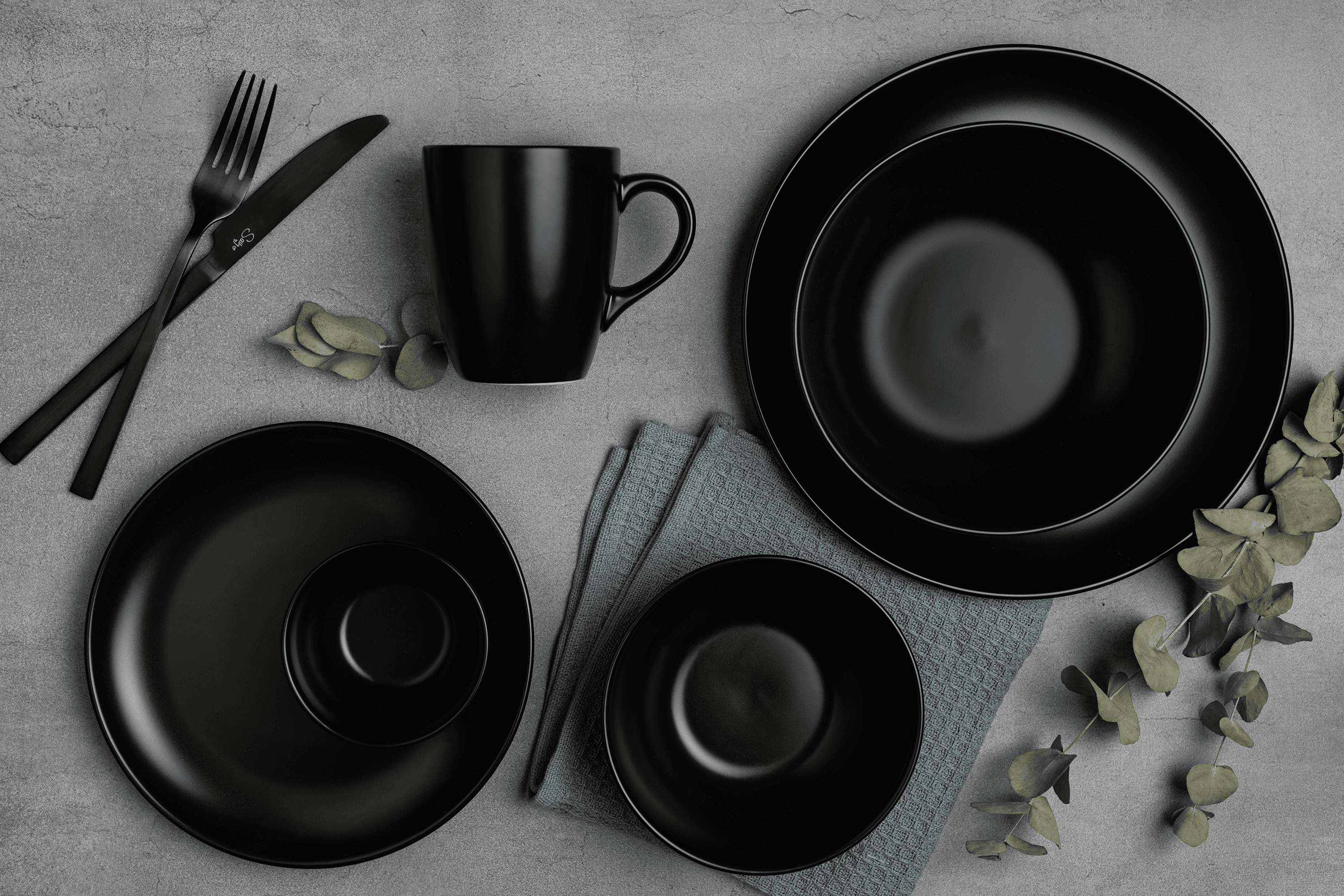 Schwarzes Stoneware-Geschirr steht auf einem Tisch