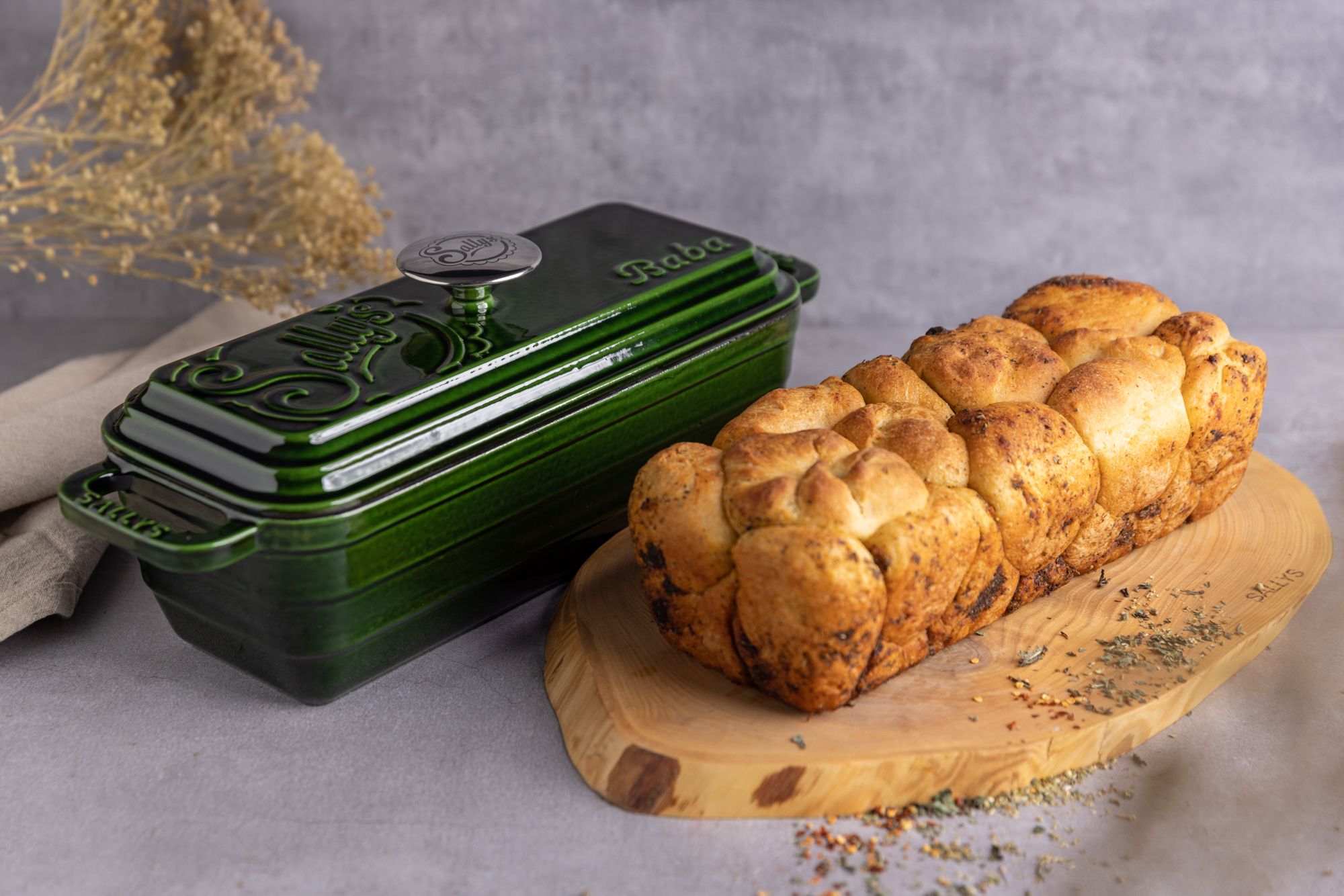 Ein Brot liegt neben der Baba Form in huntergreen