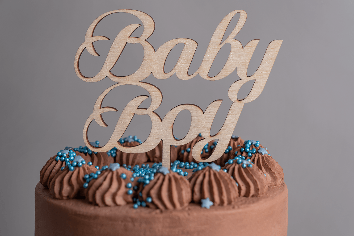 Ein Caketopper mit der Aufschrift Babyboy steckt auf einem Kuchen