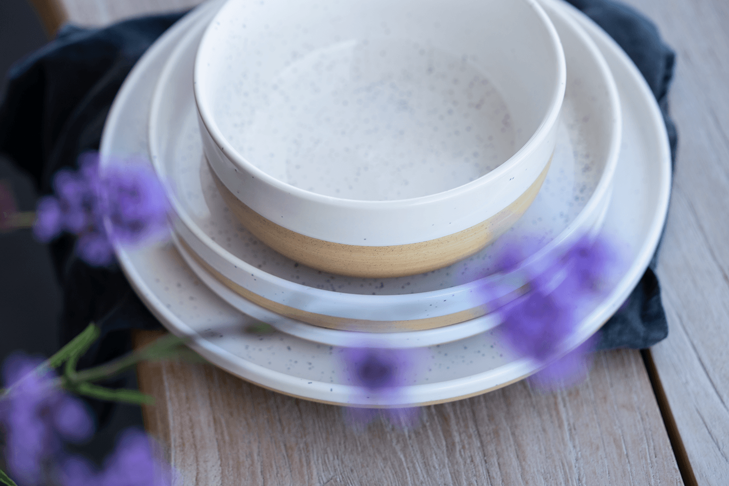 Weiß-beiges Keramikgeschirr steht auf einem Tisch