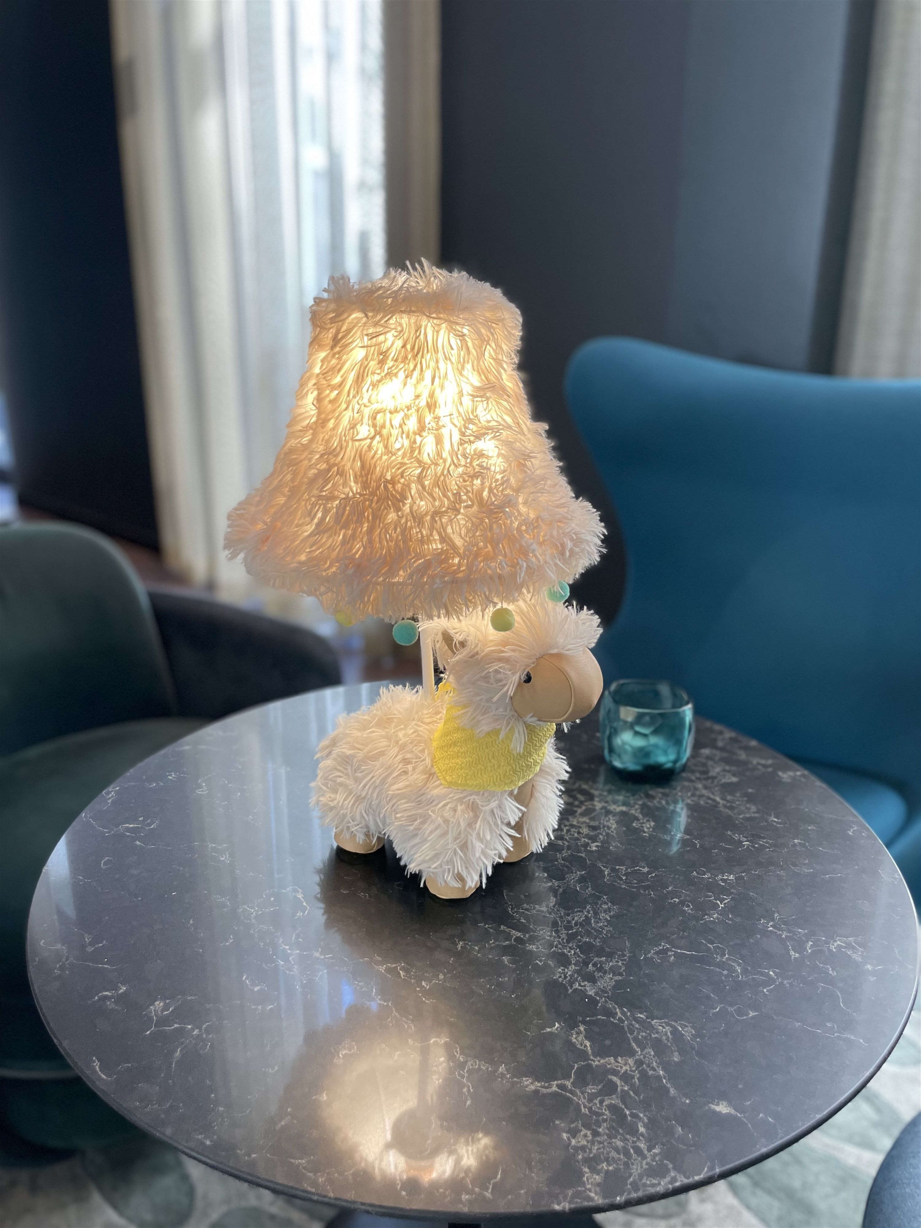 Eine Alpaka Stofftierlampe auf einem Tisch von oben