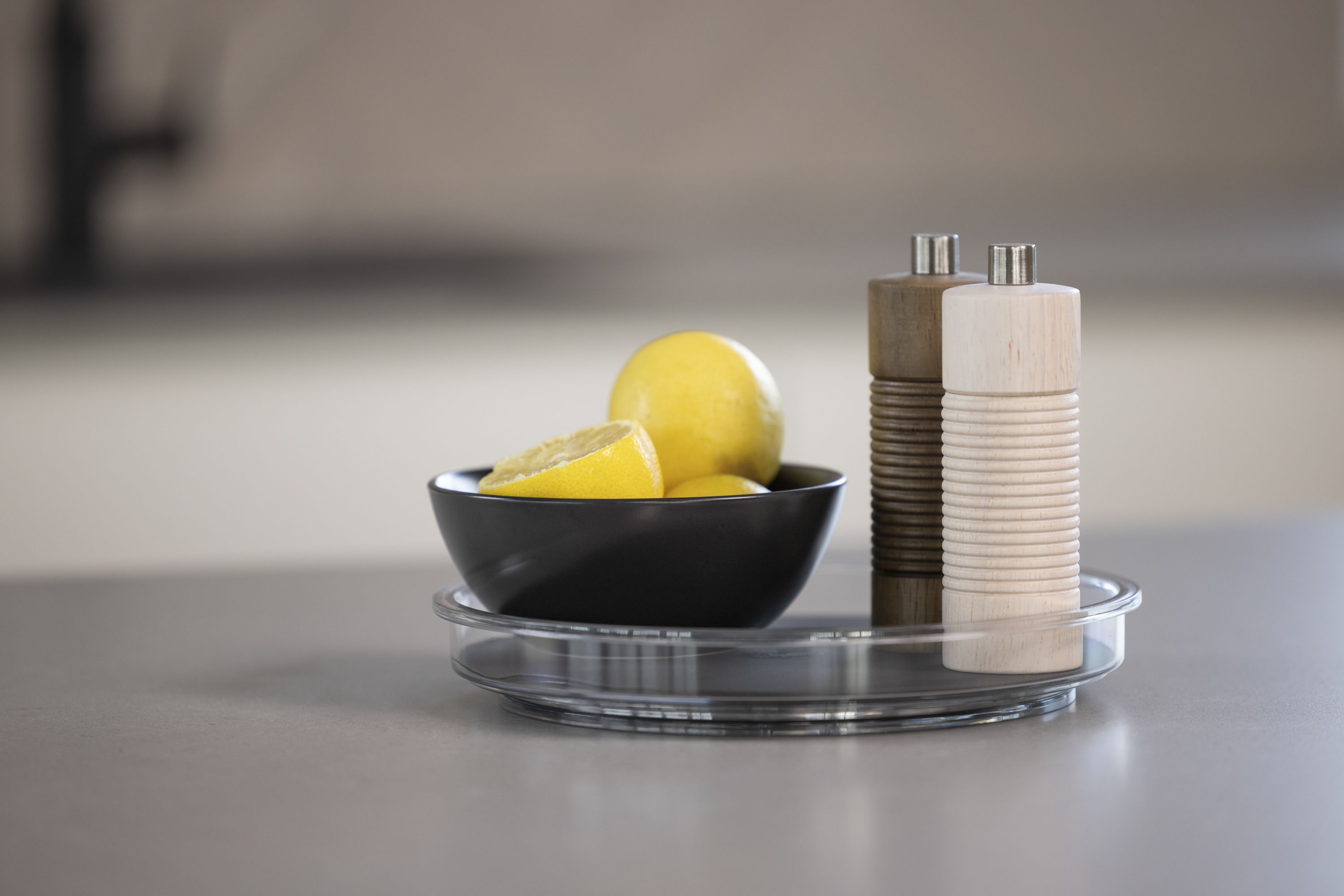 Kleine schwarze Drehplatte mit Zitronen für einen frischen Look auf dem Tisch