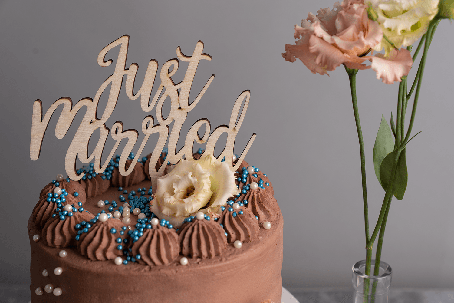 Ein Caketopper mit der Aufschrift Just Married steckt in einem Kuchen