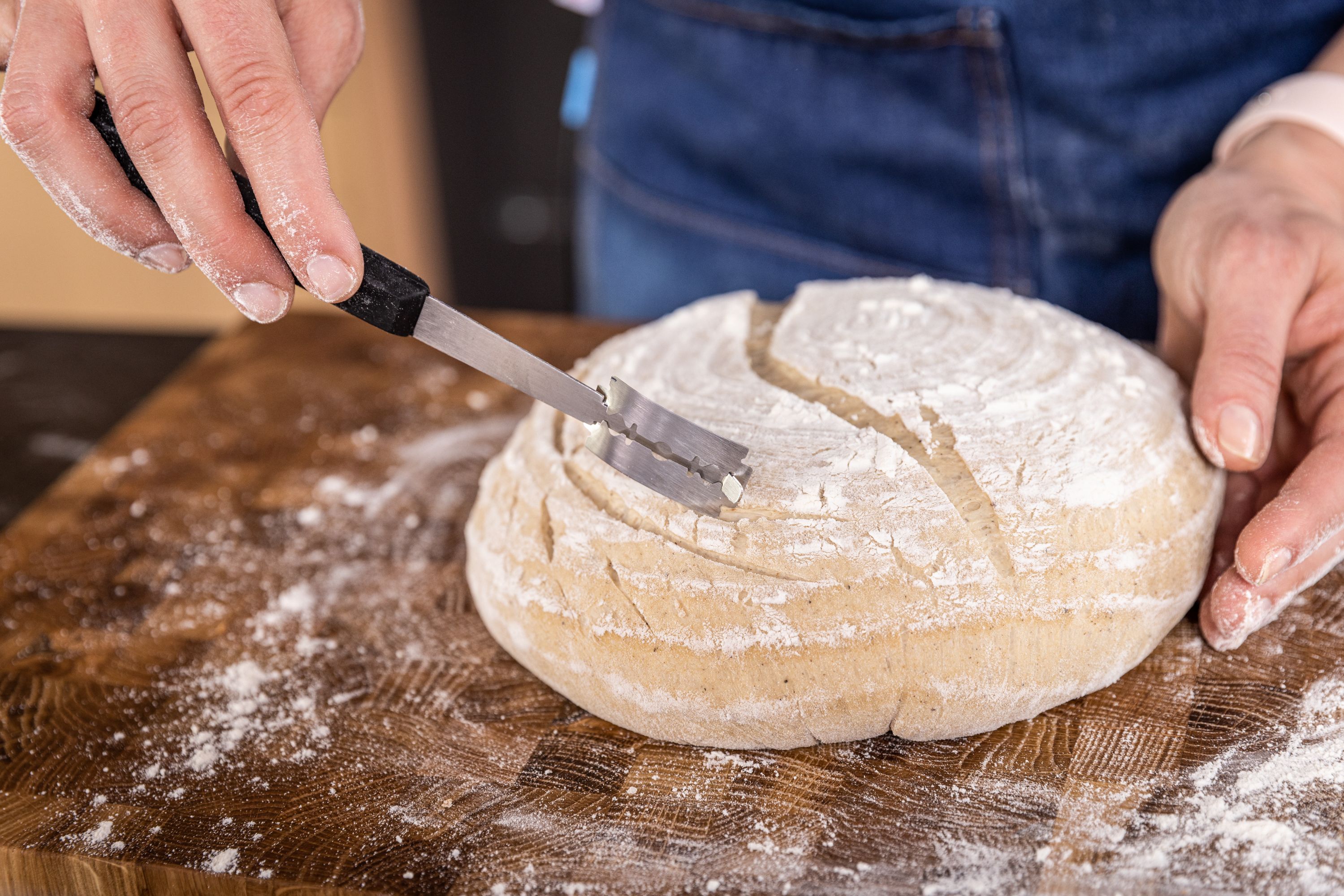 Mit dem Brotskalpell wird ein Muster in ein Brot gemacht