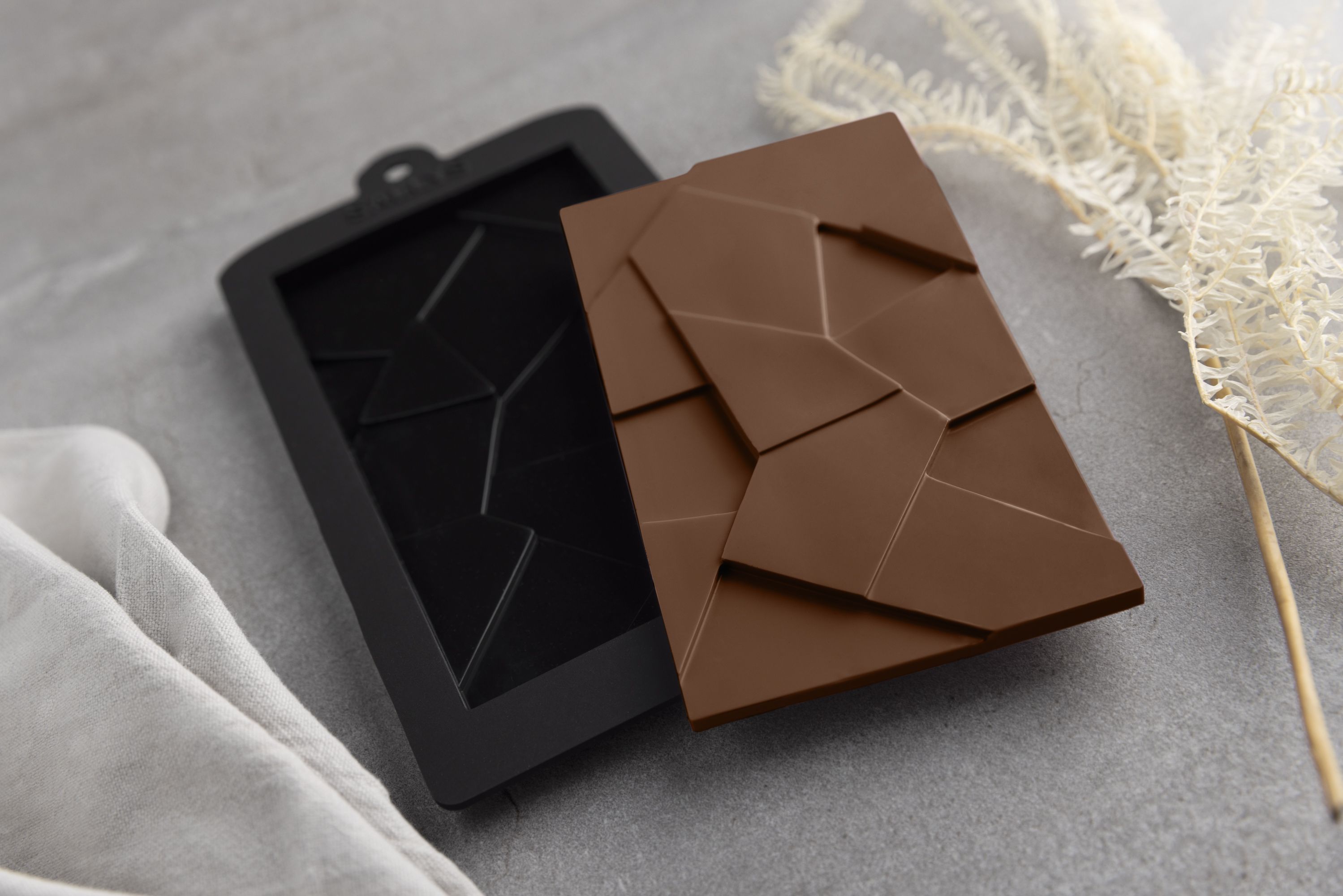 Eine Schokoladenform für Schokolade in Splitteroptik liegt auf einem Tisch