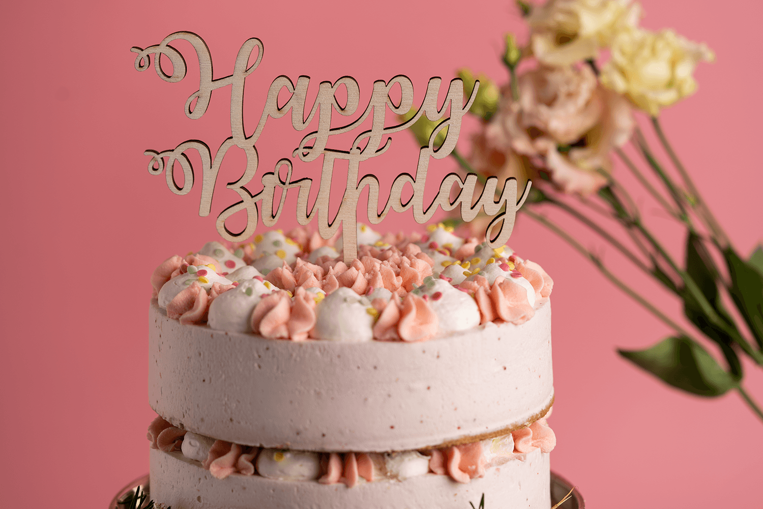 Ein Caktopper mit der Aufschrift Happy Birthday steckt in einem Kuchen