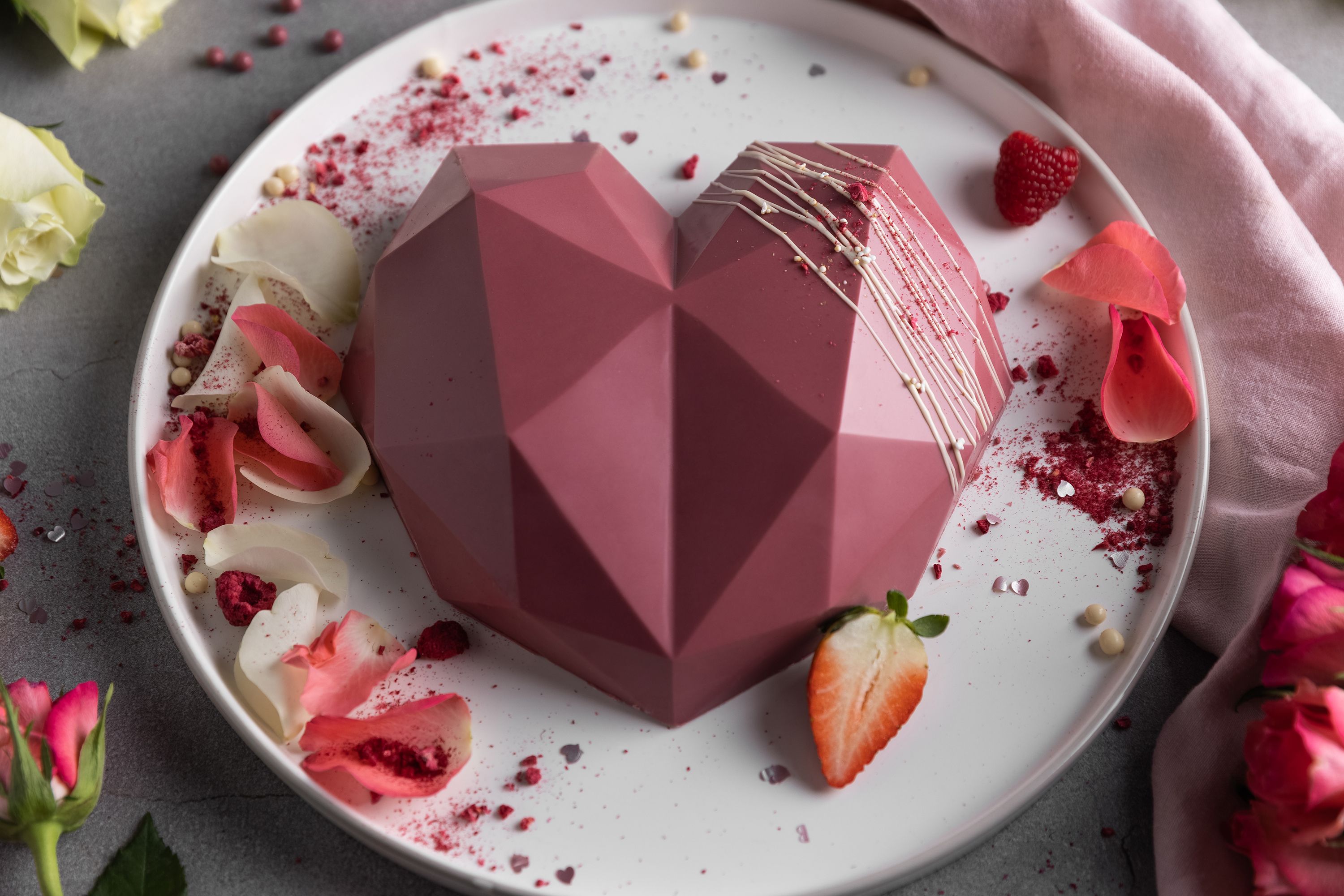 Ein 3D-Diamantherz aus Schokolade liegt auf einem Teller