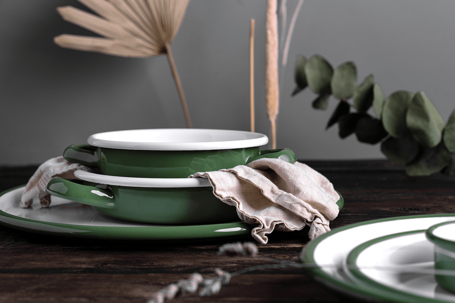Olivgrünes Emaille-Geschirr steht auf einem Tisch