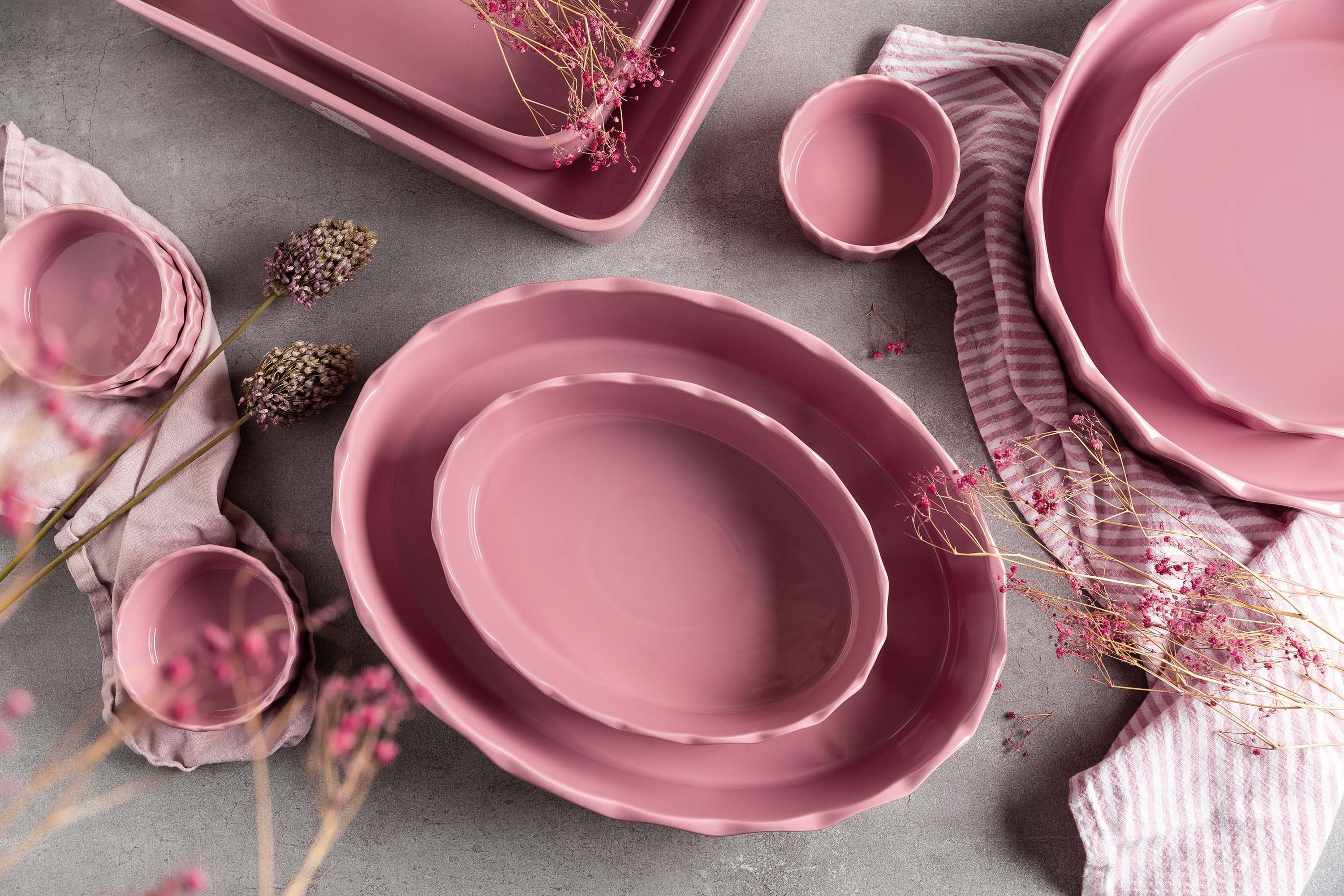 Mehrere rosa Stoneware-Ofenformen stehen auf einem Tisch